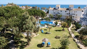 A resort with a swimming pool, lounge chairs, and a view of the sea. - AS MD 5D3 in Mijas Costa (Mijas)