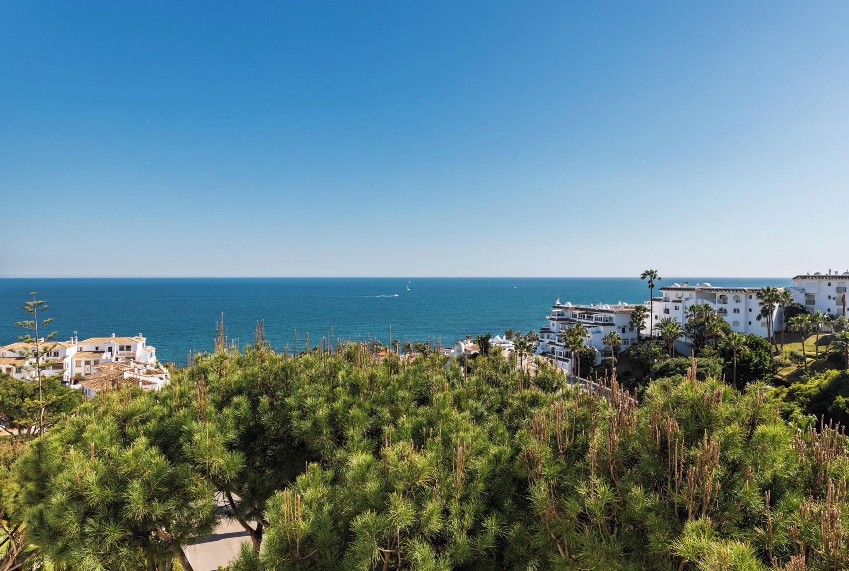 Blick auf die Küste mit Gebäuden, blauem Himmel und dem Meer.