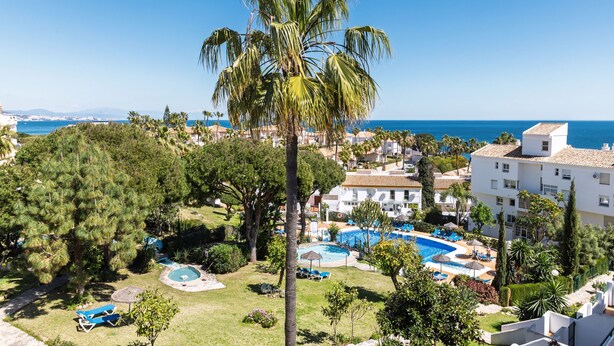 A resort with a swimming pool, lounge chairs, and a view of the sea. - AS MD 5D3 in Mijas Costa (Mijas)