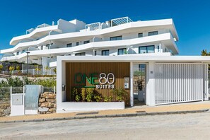 A modern building with a sign for 'ONE80 SUITES.' - AS EXT Estp ONE 80 Suites 211a (Estepona)