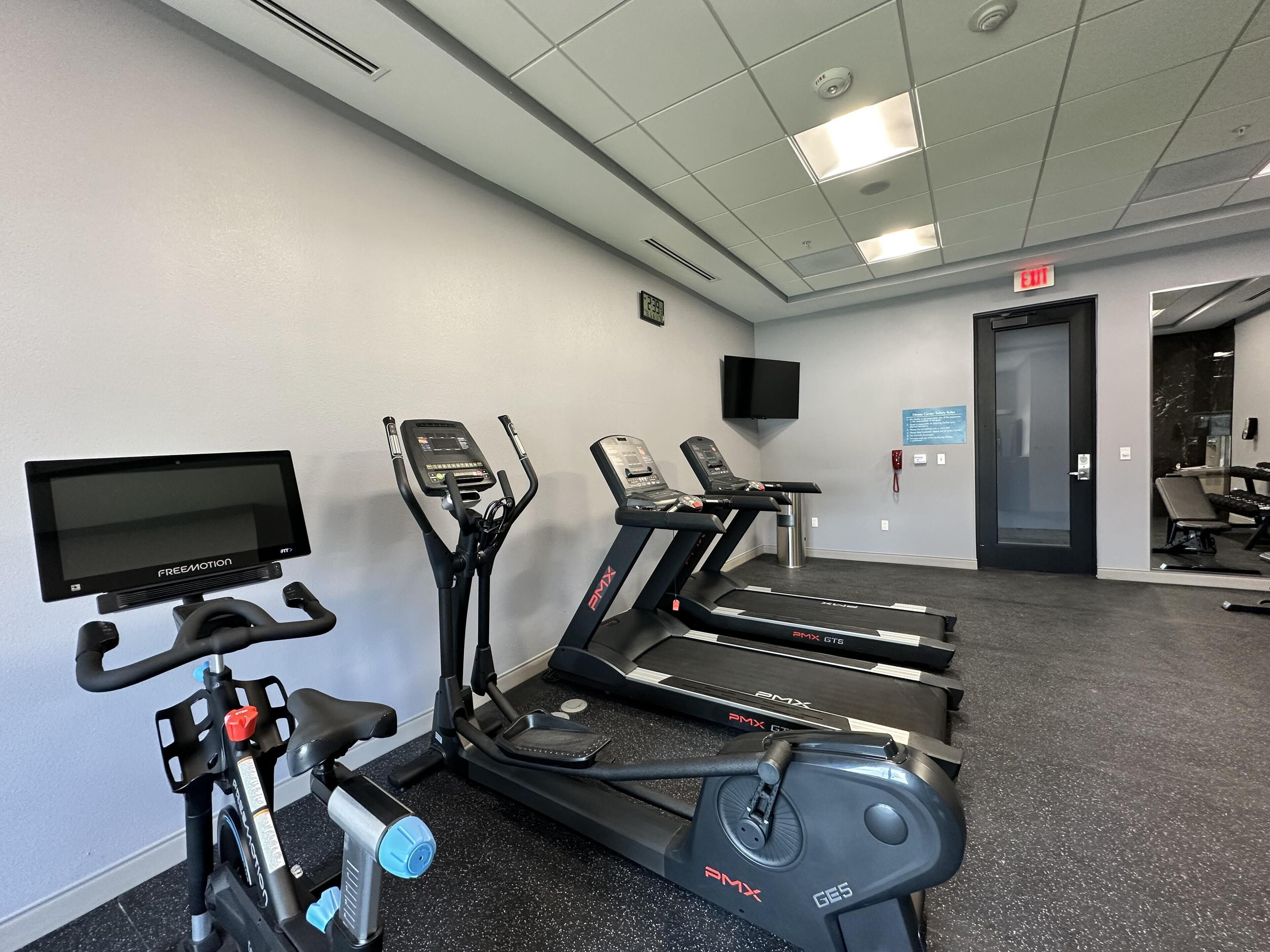 A gym with treadmills, an elliptical, and a stationary bike.