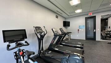 A gym with treadmills, an elliptical, and a stationary bike.