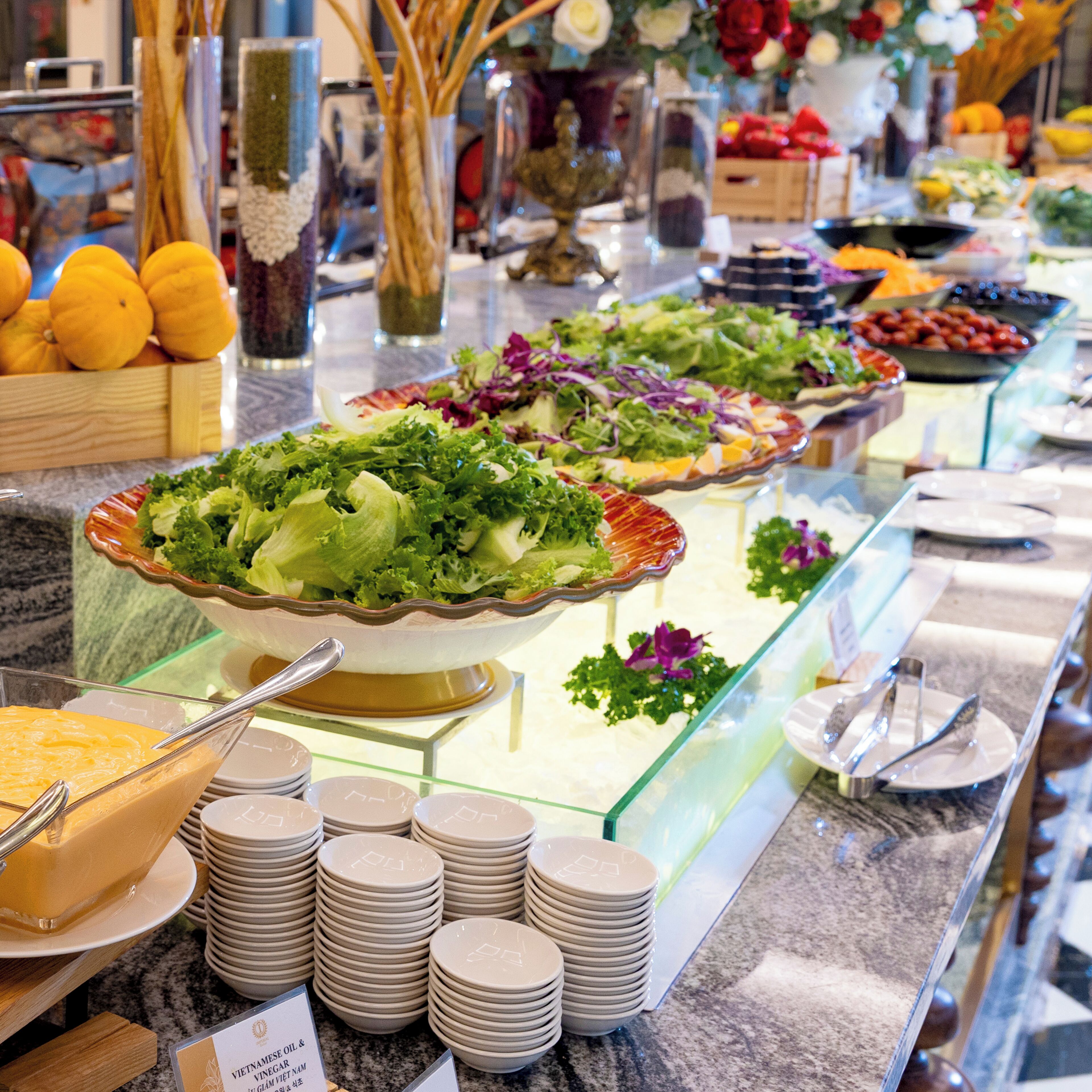 Un buffet proposant divers plats, notamment des salades et une sélection de fromages.