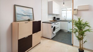 A modern kitchen with a washing machine, microwave, and a potted plant. - Timon Stunning Sea Views by Alfresco Stays (Benalmádena)
