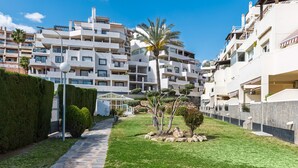 A residential building with multiple balconies, a paved pathway, and well-maintained greenery. - Timon Stunning Sea Views by Alfresco Stays (Benalmádena)