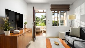 Una sala moderna con televisor de pantalla plana, mueble de madera y sofá.
