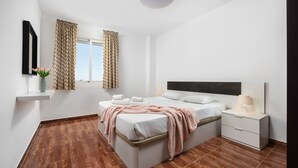 Um quarto moderno com uma cama grande, mesas de cabeceira, um criado-mudo, um espelho e uma janela com cortinas.