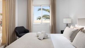 A hotel room with a bed, a chair, a nightstand with a lamp, and a window with curtains. - AS SM 175 in Mijas Costa (Mijas)