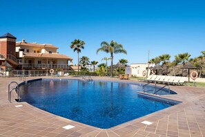 A swimming pool with a tiled deck, lounge chairs, palm trees, and a building with a tiled roof. - AS MM C02 in Mijas Costa (Mijas)