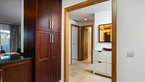 A modern kitchen with wooden cabinets, a countertop, and a view into a hallway leading to a bathroom. - AS MM C02 in Mijas Costa (Mijas)