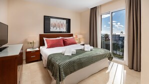 A hotel room with a bed, a desk, a TV, a window with curtains, and a framed picture on the wall. - AS MDS 310 in Mijas Costa (Mijas)