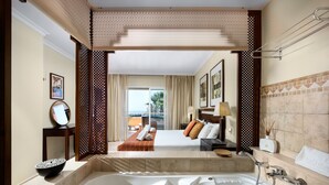 A hotel room with a large bathtub, a bed with pillows, a bedside table with a lamp, and a view of the outside. - AS MM A09 in Mijas Costa (Mijas)