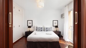 A bedroom with a large bed, two bedside tables with lamps, a wardrobe, and a window with curtains. - AS MDS 113 in Mijas Costa (Mijas)