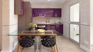 A modern kitchen with purple cabinets, a glass dining table, and black chairs. - AS MDS 113 in Mijas Costa (Mijas)