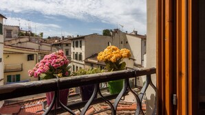 A balcony with a railing, a door, and a view of buildings and a clear sky. - Apartments Florence - Boboli Balcony Rooftop View Florence City Center (Firenze)