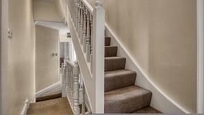 A staircase with a white balustrade and carpeted steps. - Spacious 4BR 3BA House Near Barons Court Station (London)