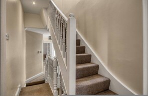 Eine Treppe mit weißer Balustrade und Teppichstufen.