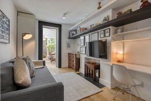 A modern living room with a sofa, TV, and a desk area. - An Architect s Home - Vauxhall 1 Bed Apt - Zone 1 (London)