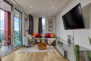 Ein modernes Wohnzimmer mit Sofa, Couchtisch und Fernseher.