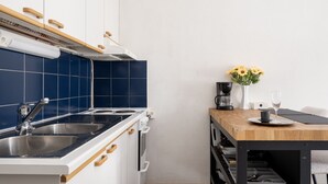 Una cocina con estufa, lavamanos y encimera de madera.