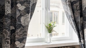 Un dormitorio con ventana, radiador y planta en maceta.