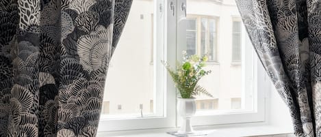Un dormitorio con ventana, radiador y planta en maceta.