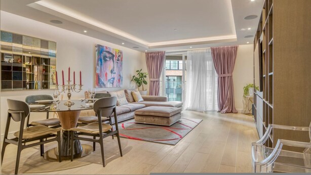 A modern living room with a dining area, a sofa set, a coffee table, and a bookshelf. - Luxe Creek Riverside Air-conditioned 2br 2bath (London)