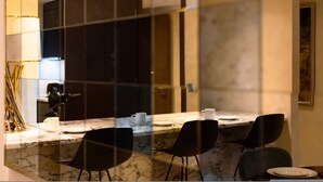 A modern dining area with a marble countertop, black chairs, and a white table setting. - Luxe Creek Riverside Air-conditioned 2br 2bath (London)