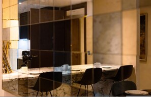 A modern dining area with a marble countertop, black chairs, and a white table setting. - Luxe Creek Riverside Air-conditioned 2br 2bath (London)
