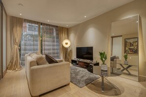 Ein modernes Wohnzimmer mit einer Couch, Fernseher und Zimmerpflanzen.