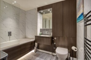 Ein modernes Badezimmer mit Badewanne, Toilette und Waschbecken.