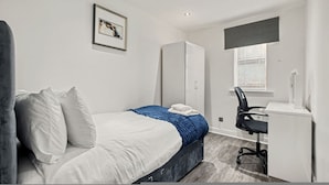 Une chambre à coucher avec un lit, un bureau et une chaise.