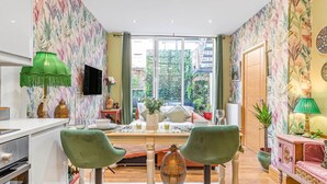 A modern living room with a sofa, chairs, a TV, and a dining area. - Charming 2bed Garden Apartment in Covent Garden (London)