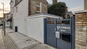 Ein verschlossenes Tor zu einem Wohnanwesen, mit einem Schild, das '121A STABLES' anzeigt.