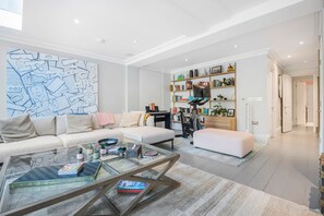 Una sala de estar moderna con sofá, mesa de centro y estantería.