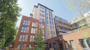 A multi-story residential building with a brick facade, multiple balconies, and a well-maintained garden area. - Modern Charming 2 bed Flat With Amazing Views (London)