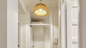 A hallway with wooden flooring, white walls, and a hanging light fixture. - Comfortable 2-bed in Zone 2 (London)