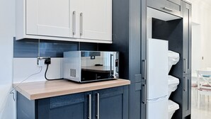 A modern kitchen with built-in appliances, a wooden countertop, and dark cabinetry. - Group-Friendly Home | TV in Every Room, WiFi & Parking (Bon-y-maen)