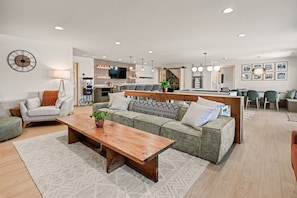A modern living room with a sofa, coffee table, and a TV. - Beach•Arcade•Hot tub•Putting Green•Dog-friendly! (New Lisbon)