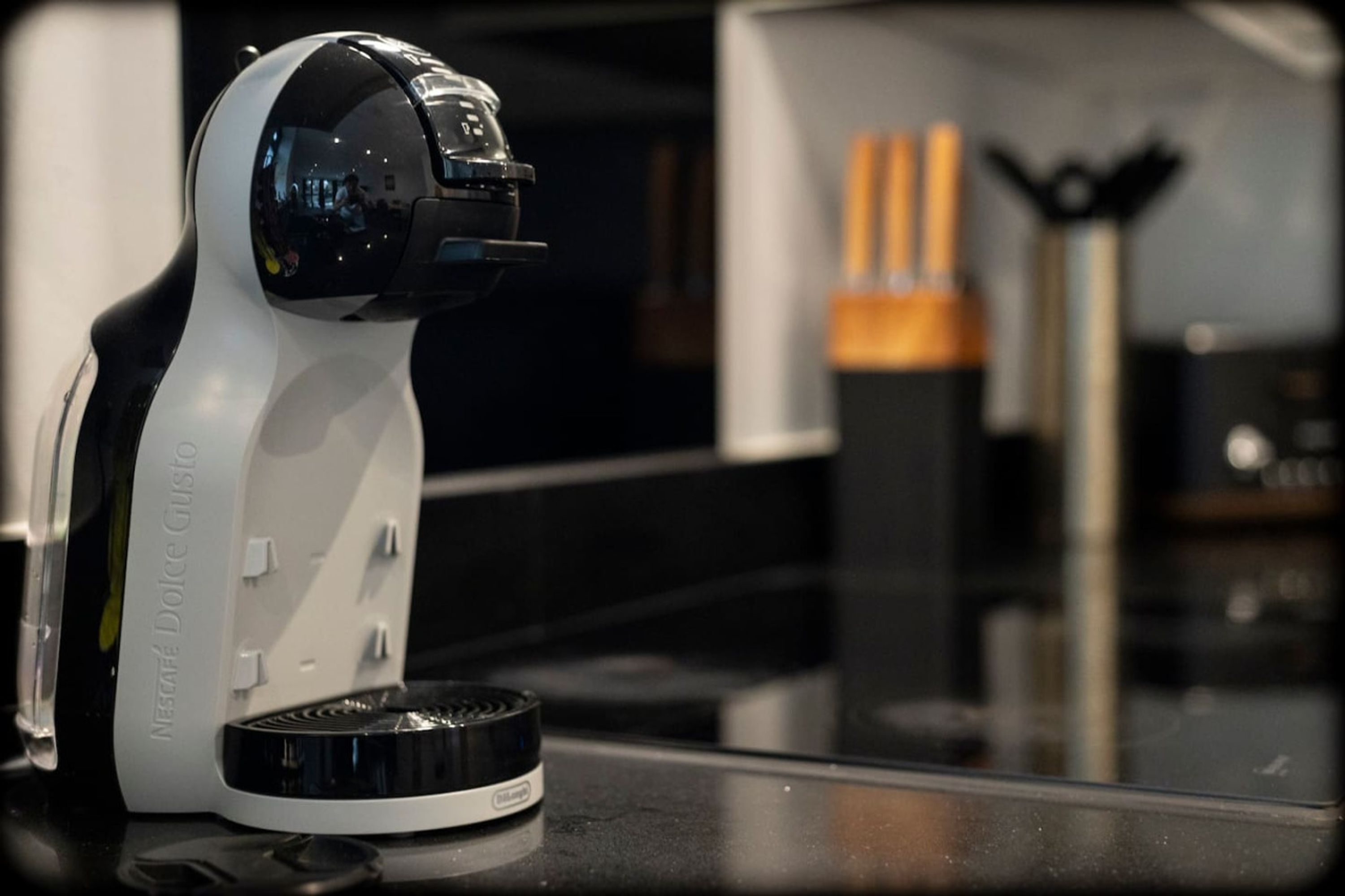 A coffee machine on a countertop with a blurred background.