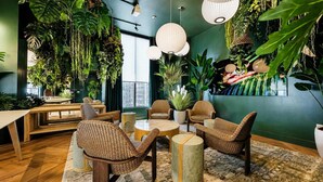 A room with wicker furniture, hanging plants, and a view of the city. - Skyline View 1BR + Den Near Port Miami (Miami)