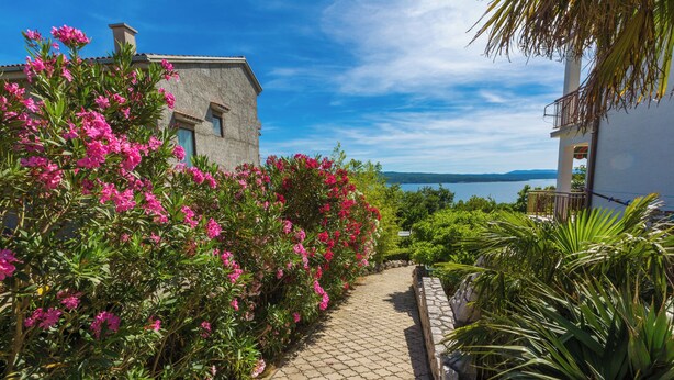 A paved pathway leading to a building with a view of a body of water. - Apartment created for enjoyment (Crikvenica)