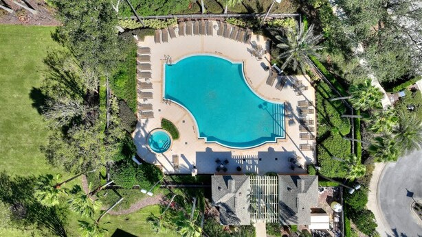An aerial view of a resort with a large swimming pool, sun loungers, and palm trees. - Mouse House 5 miles to Disney sleeps 9 (Kissimmee)