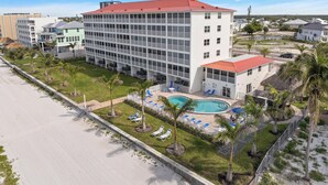 Un hôtel doté d’une piscine, de plusieurs étages et d’un toit rouge.