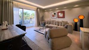 Een moderne woonkamer met een bank, een eettafel en een balkon met uitzicht.