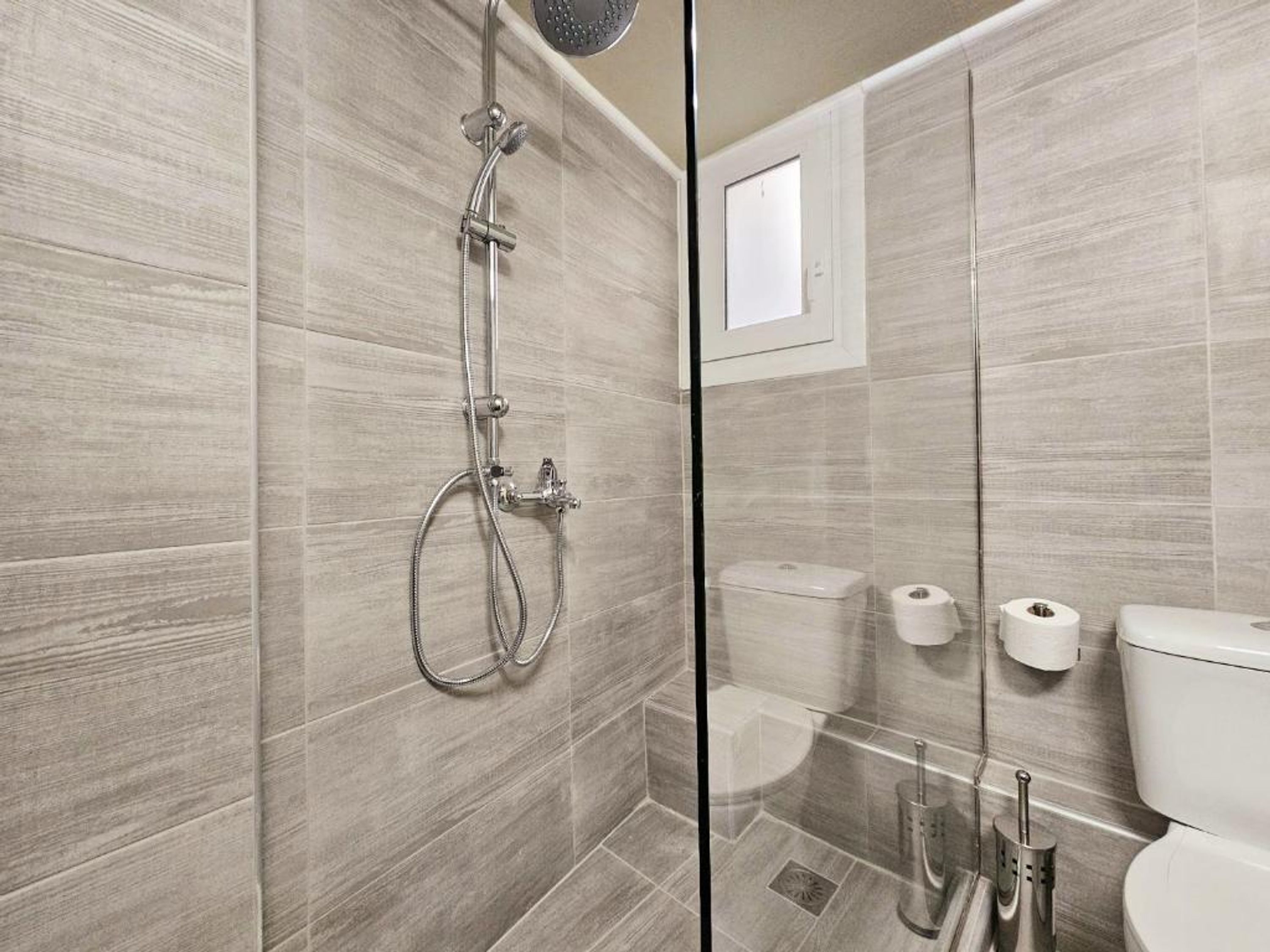 Ein modernes Badezimmer mit einer Duschkabine aus Glas, einer Toilette und einem Bidet.