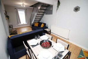 Un espace de vie moderne comprenant un coin repas, un escalier et un radiateur.