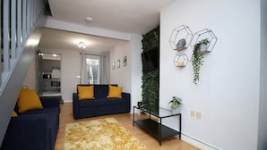 Uma sala de estar moderna com um sofá, mesa de centro e prateleiras decorativas na parede.