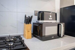 Une cuisine équipée d’une cuisinière, d’un grille-pain et d’un porte-couteaux.