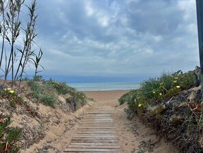 A wooden pathway leading to a beach with a view of the ocean and overcast sky. - Flamingo Beachfront Views, Direct Beach Access (Dénia)